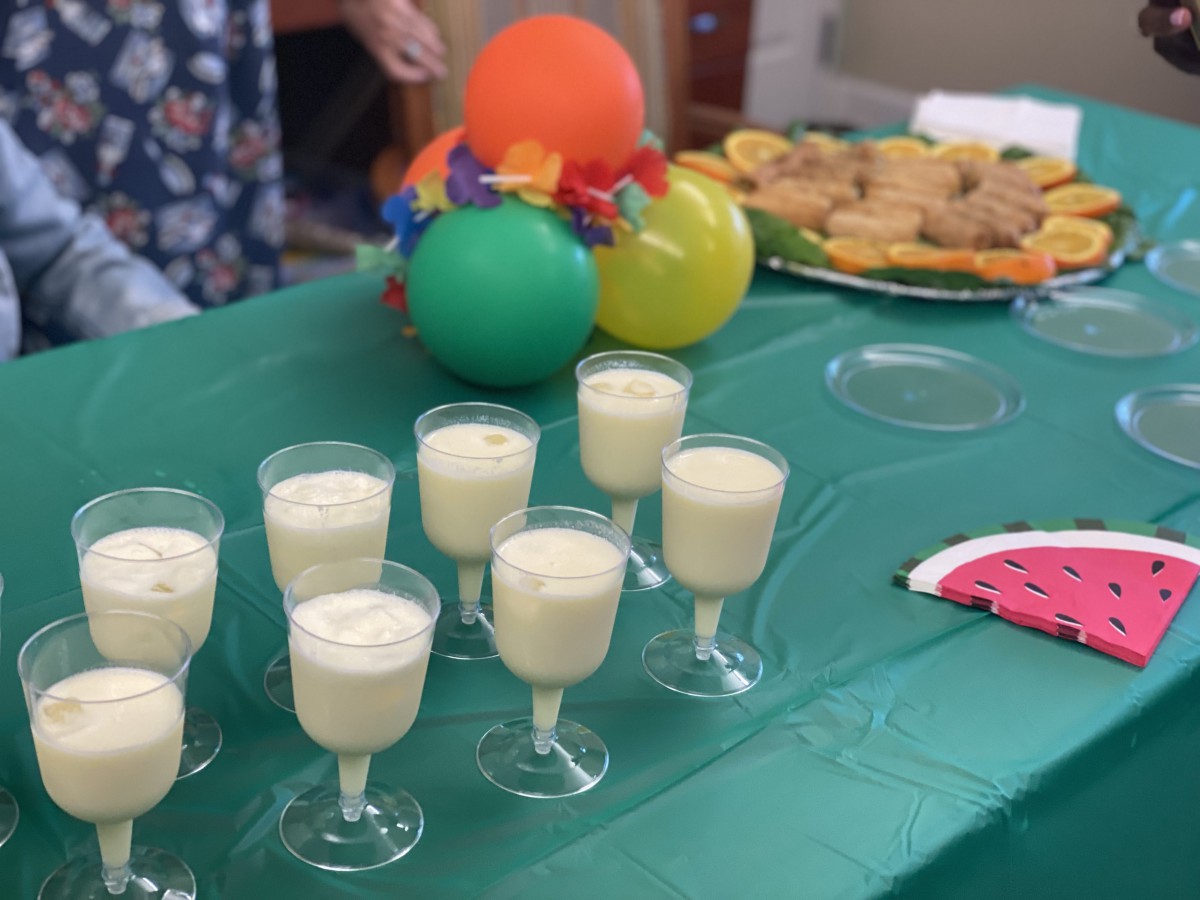 A festive table setup with drinks and colorful balloons.