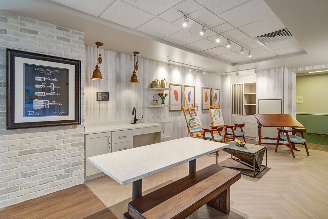 A modern interior design featuring a kitchen area with wood accents, stylish lighting, and framed artwork.
