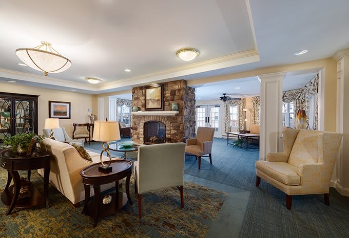 A cozy living room featuring comfortable seating and a stone fireplace.
