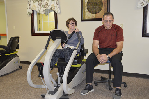 A man and a woman engage in a physical therapy session, utilizing specialized exercise equipment.