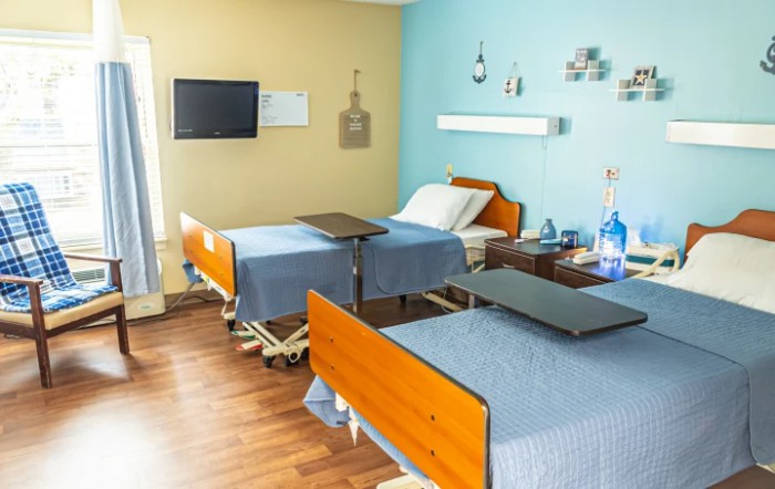 A clean and organized hospital room with two beds and essential medical equipment.