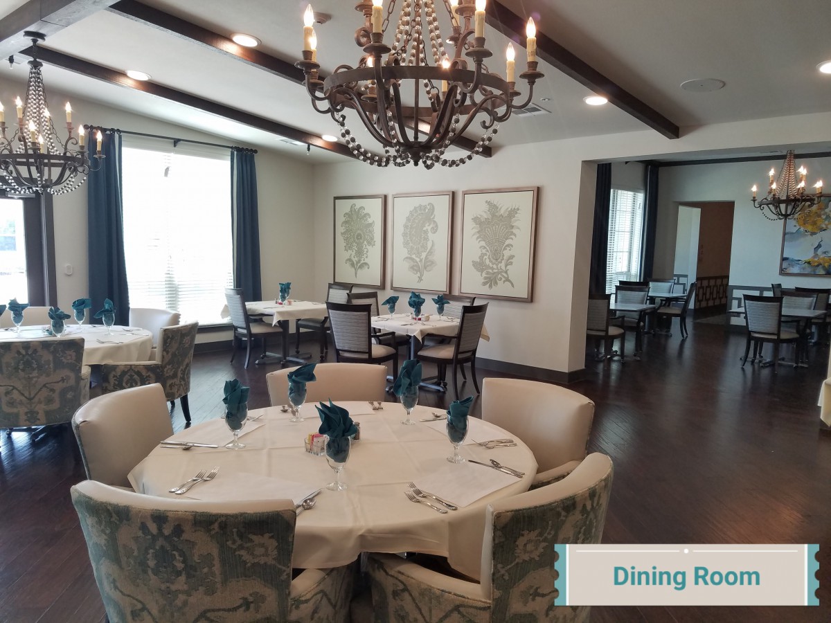 A beautifully decorated dining room with a chandelier and round tables.