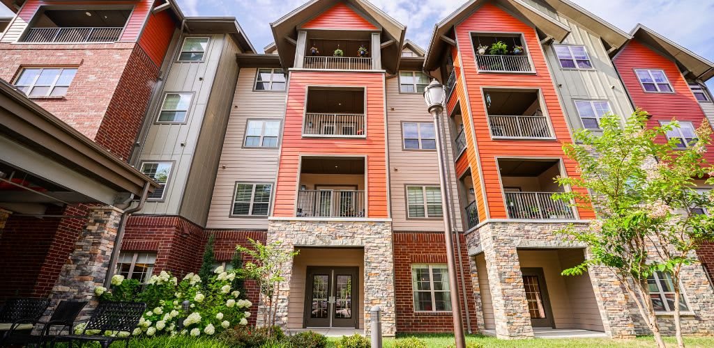 A modern apartment building with a mix of stone and siding exteriors.