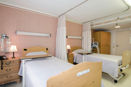 A view of a hospital patient room featuring multiple beds and a calming interior.