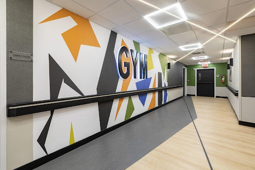 A vibrant gym interior featuring dynamic wall art and a sleek design.