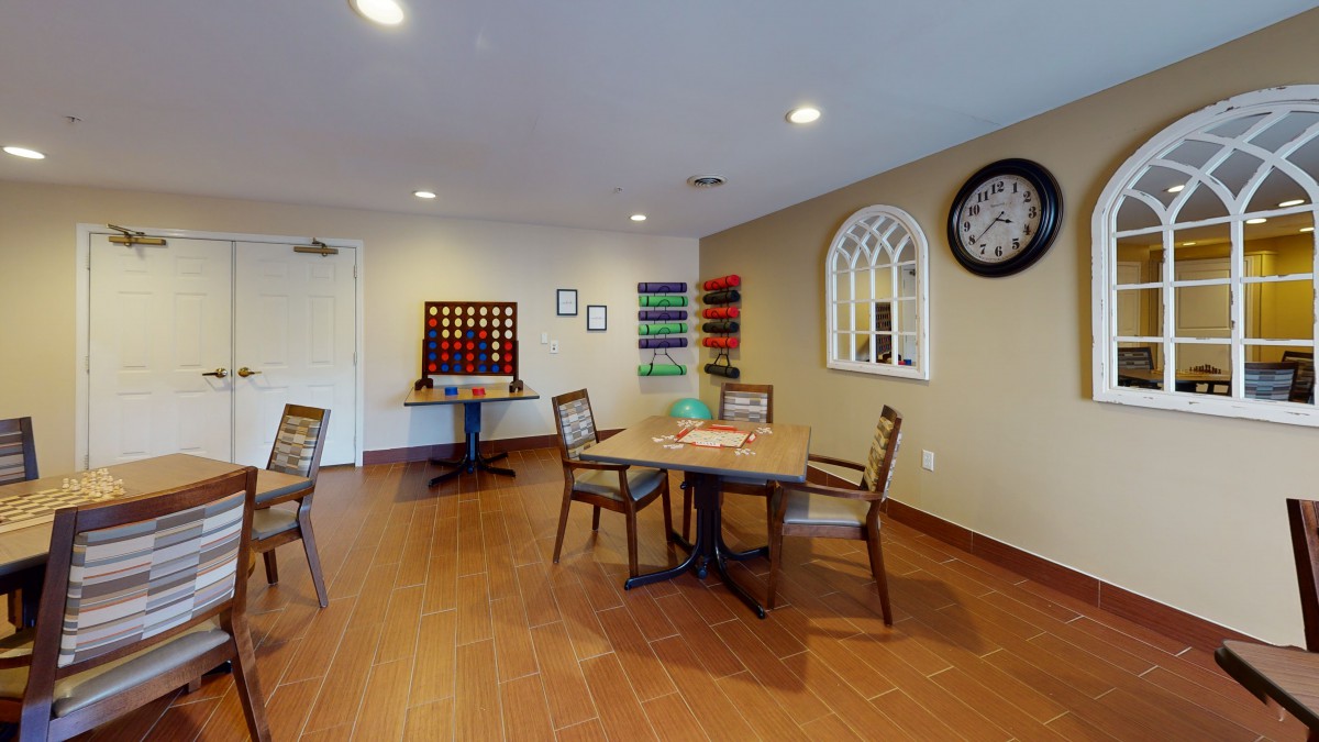 A cozy game room with a table, chairs, and wall decorations.