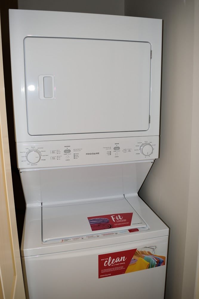 A stacked washer and dryer unit in a home setting.