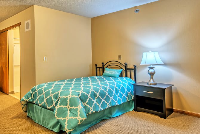 A cozy bedroom with a single bed and nightstand.