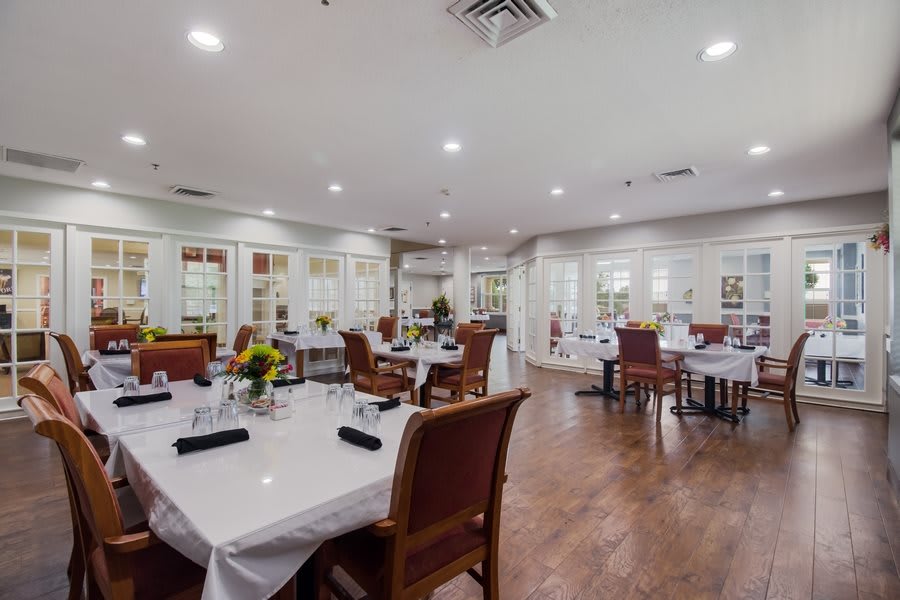 A cozy restaurant dining area with elegantly set tables and comfortable seating.