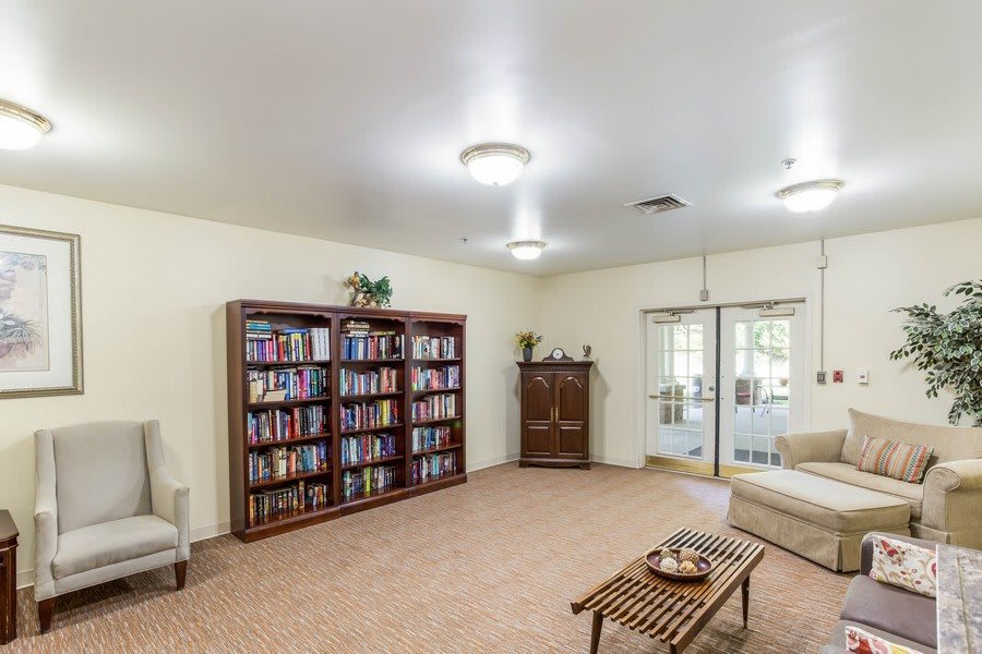 A cozy living room with a large bookshelf, sofa, and a coffee table.