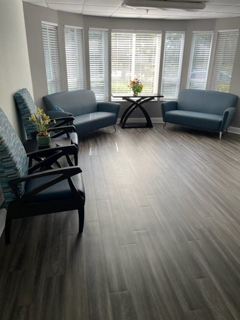 A bright waiting room with comfortable seating and a large window.