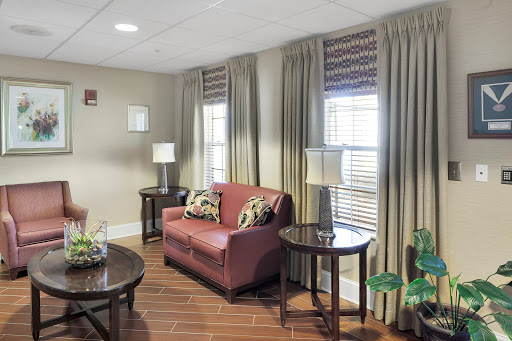 A cozy living room featuring a comfortable sofa, stylish lamps, and elegant curtains.