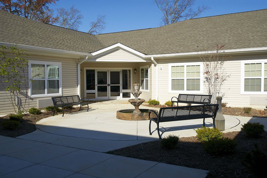 A peaceful residential courtyard with benches and a central fountain.