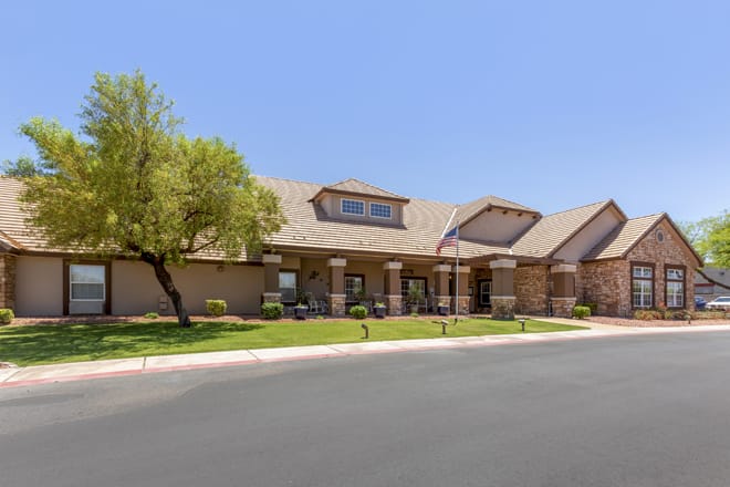 A suburban building with a neatly landscaped exterior and clear blue sky.