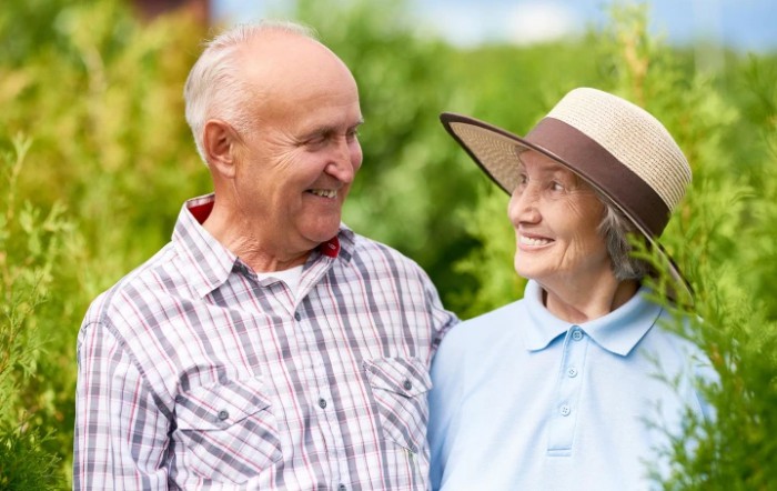 An elderly couple smiling and enjoying a day outdoors.