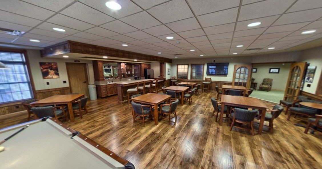 An inviting dining area with wooden flooring and neatly arranged tables and chairs.