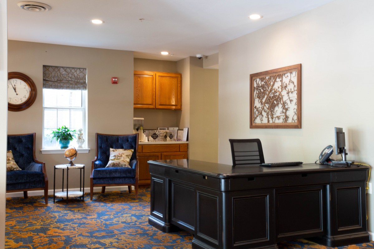 A cozy office interior with a large desk, comfortable seating, and decorative artwork.