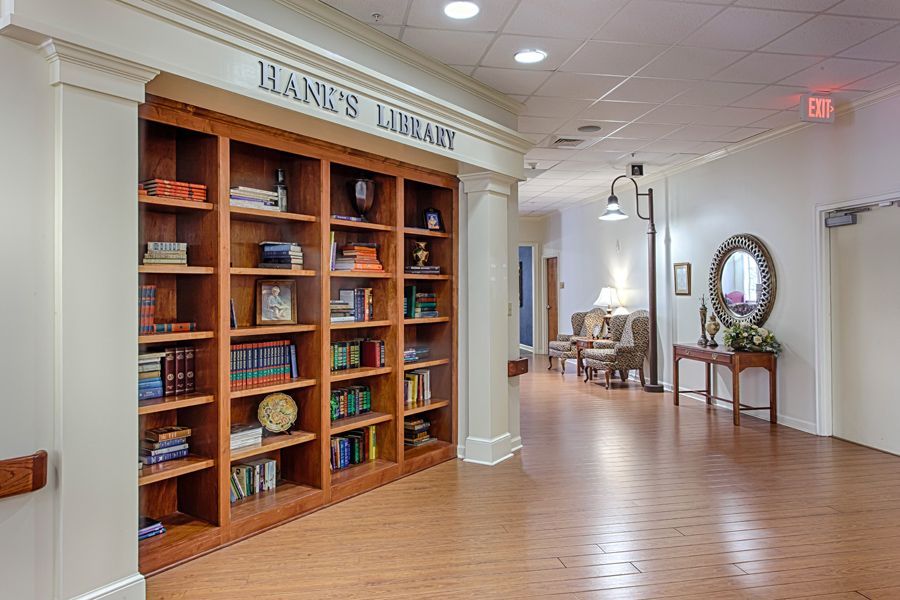 A cozy library corner with wooden bookshelves and comfortable seating.