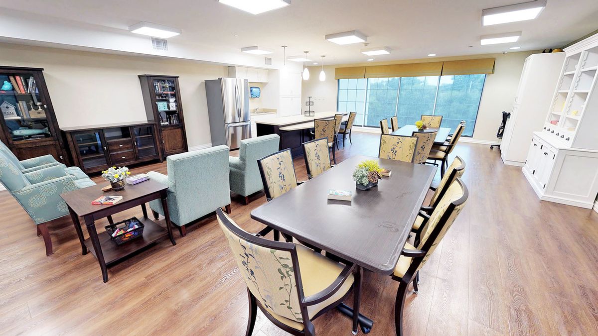 A modern dining and living area with stylish furniture and ample lighting.