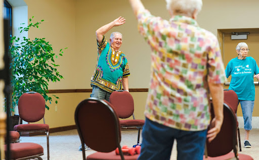 Seniors participating in a lively exercise session, promoting health and social interaction.