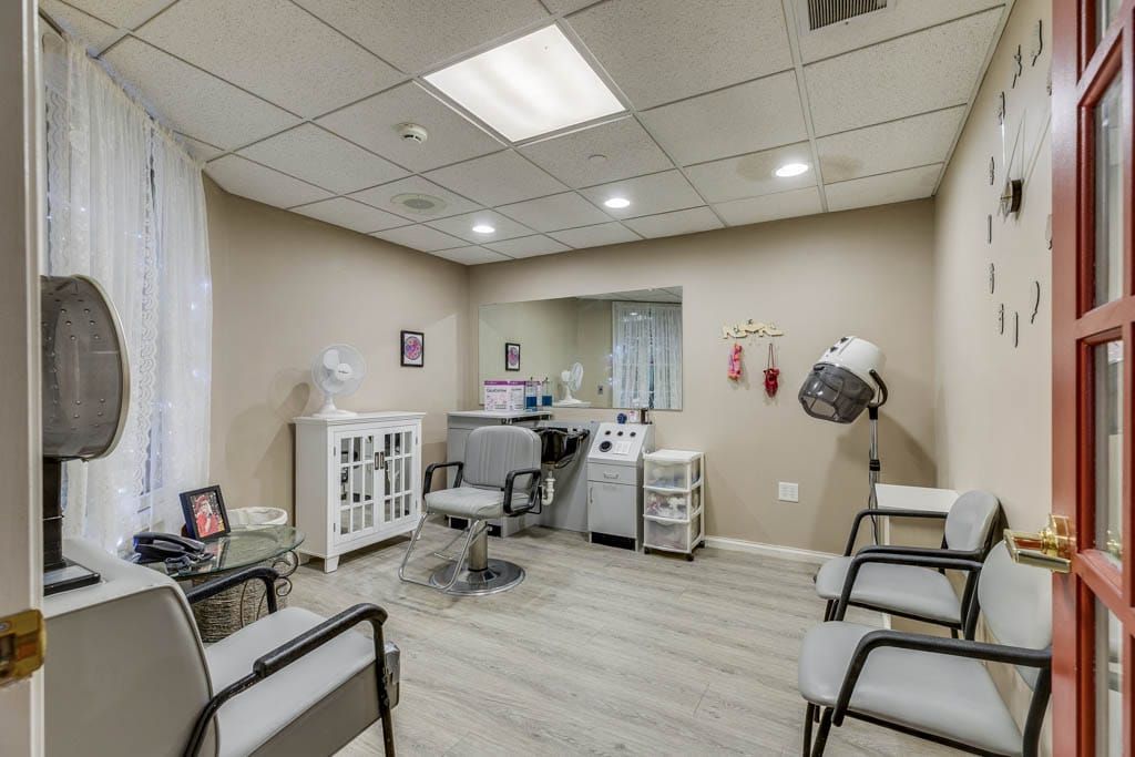 A modern hair salon interior featuring styling chairs, a mirror, and a hair dryer.