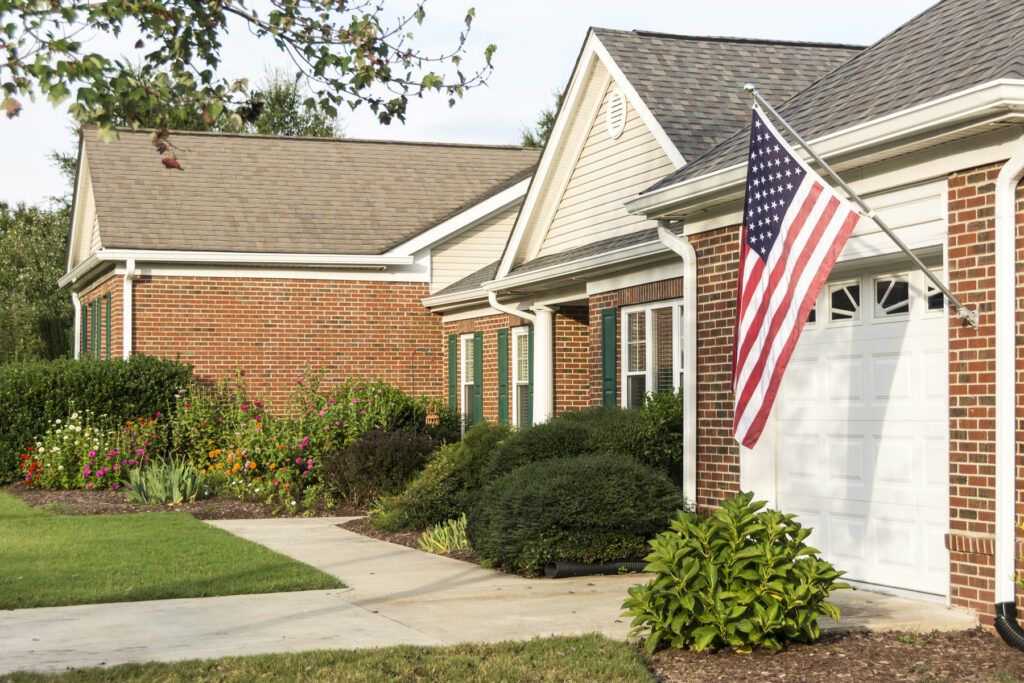 A suburban house with an American flag displayed near the entrance.