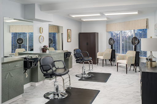 A modern hair salon featuring stylish furnishings and ample natural light.