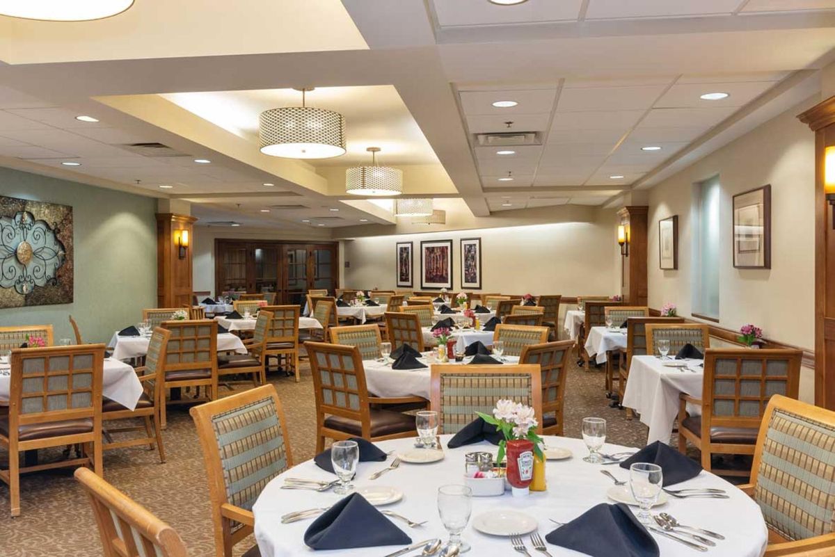 An elegantly arranged dining room with multiple tables set for guests.