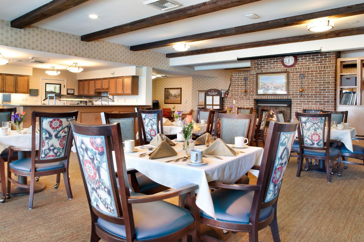 A cozy dining room with a neatly set table and elegant chairs.