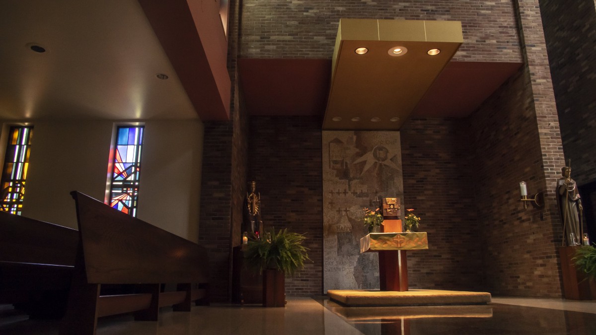 A serene church interior featuring an elegant altar and religious artwork.
