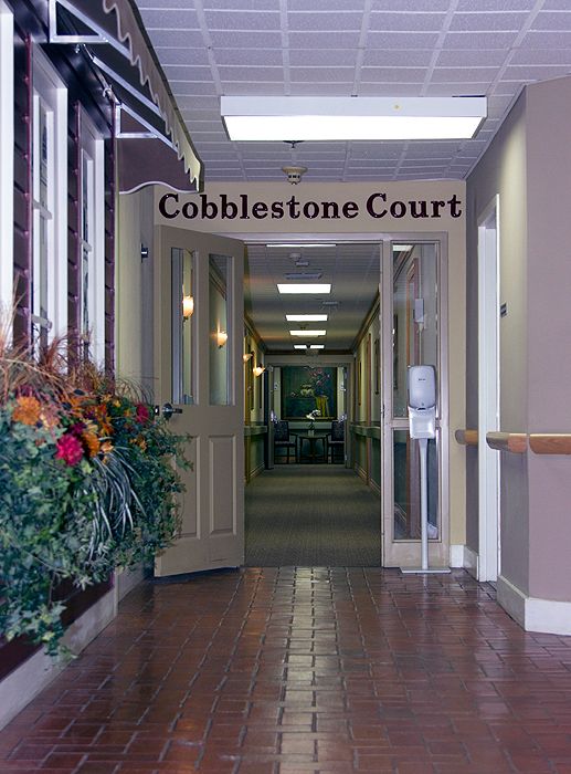 Entrance to Cobblestone Court with decorative flower arrangement.