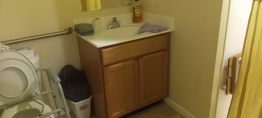 A simple bathroom sink area featuring a wooden vanity and essential items.