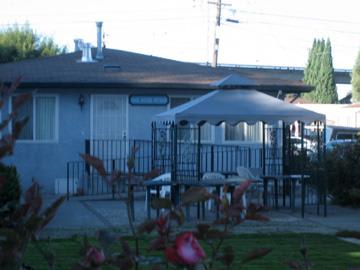 A view of a residential backyard with a patio area and umbrella.