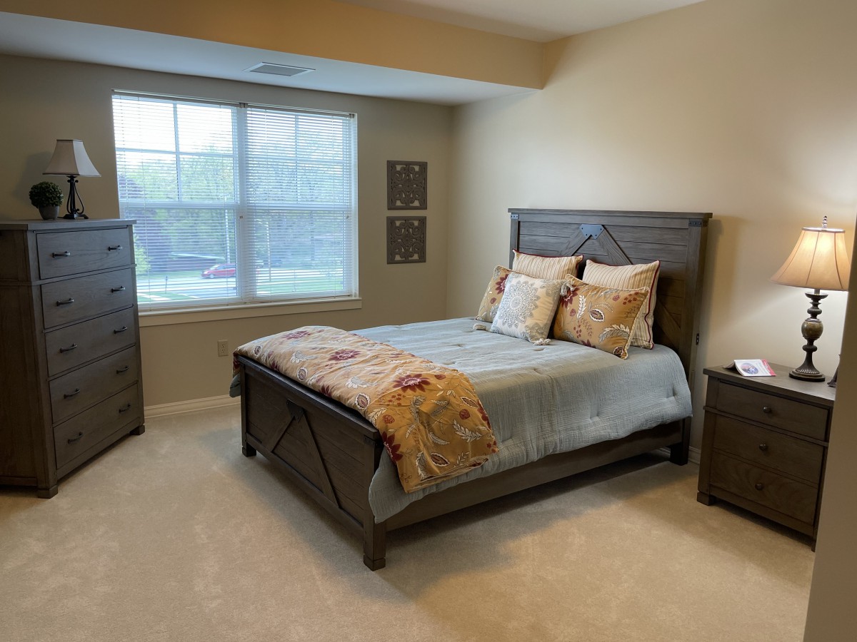 A cozy bedroom with a neatly made bed, side tables, and a window allowing natural light to brighten the space.