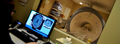 An MRI machine with a displayed brain scan, indicating a medical examination in progress.