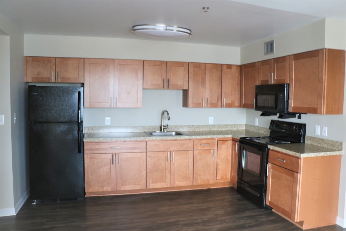A modern kitchen with wood cabinets and sleek appliances.