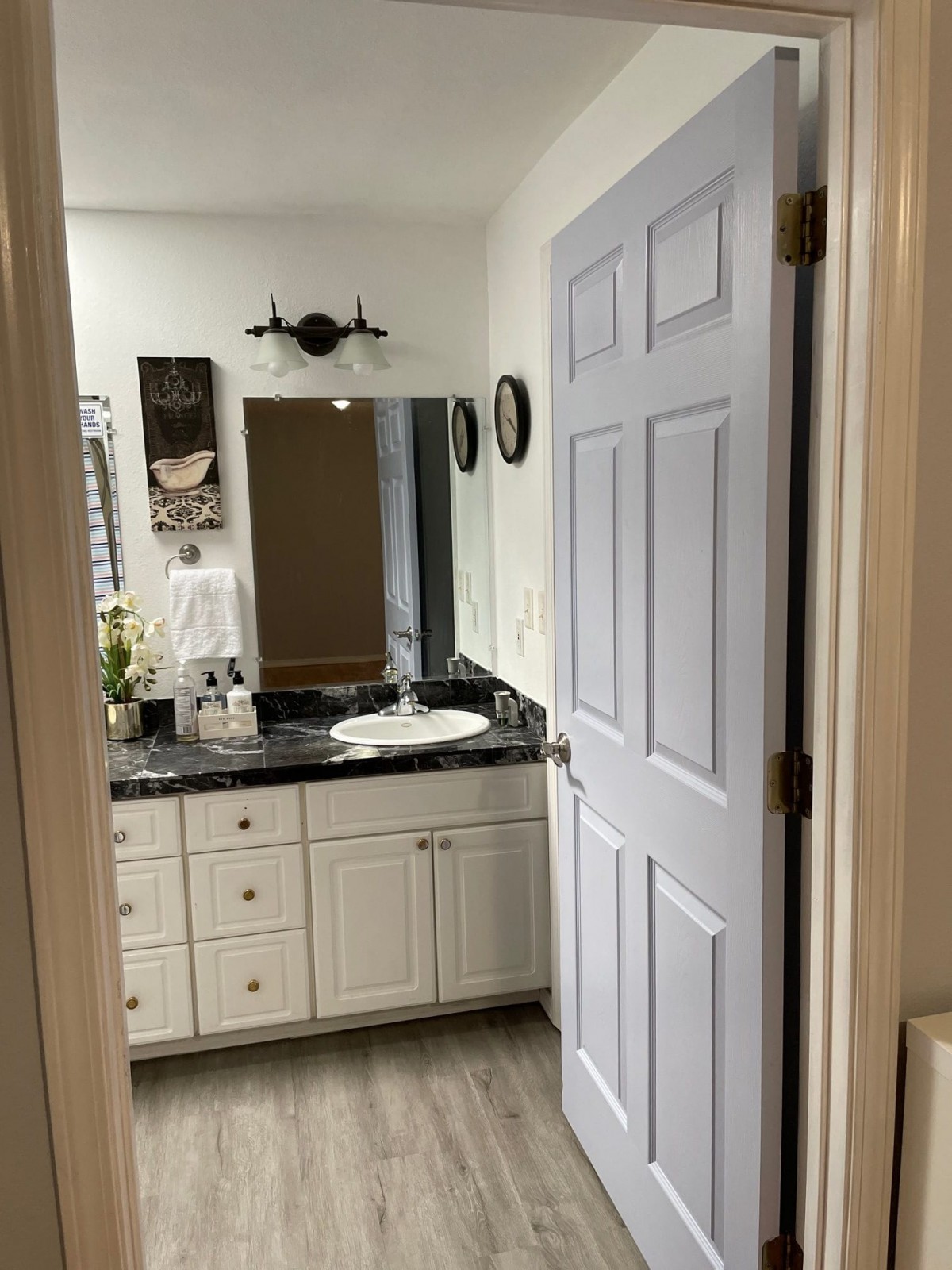 A modern bathroom with white cabinetry and a granite countertop.