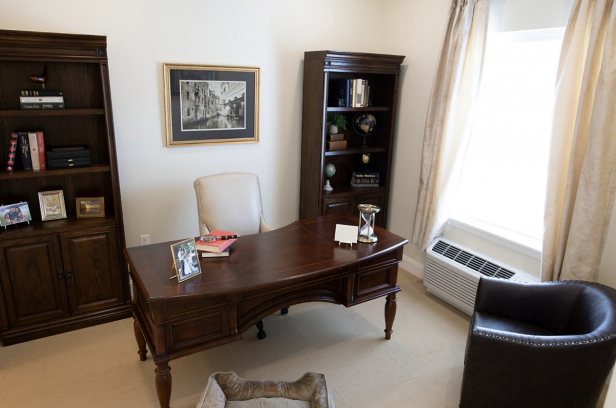 A well-organized office space with a desk, chair, and bookshelf.