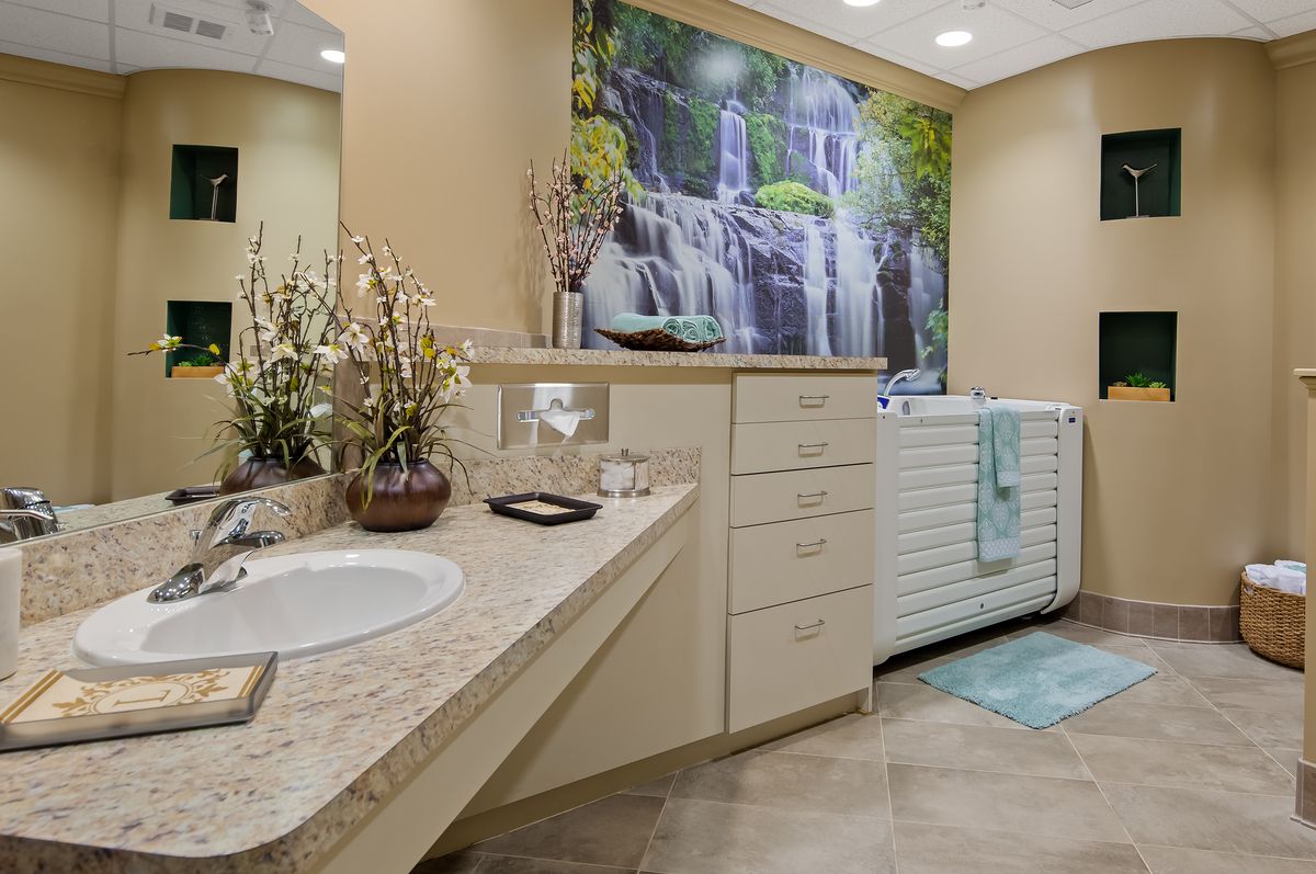 Modern bathroom with a sink, bathtub, and a large waterfall artwork on the wall.