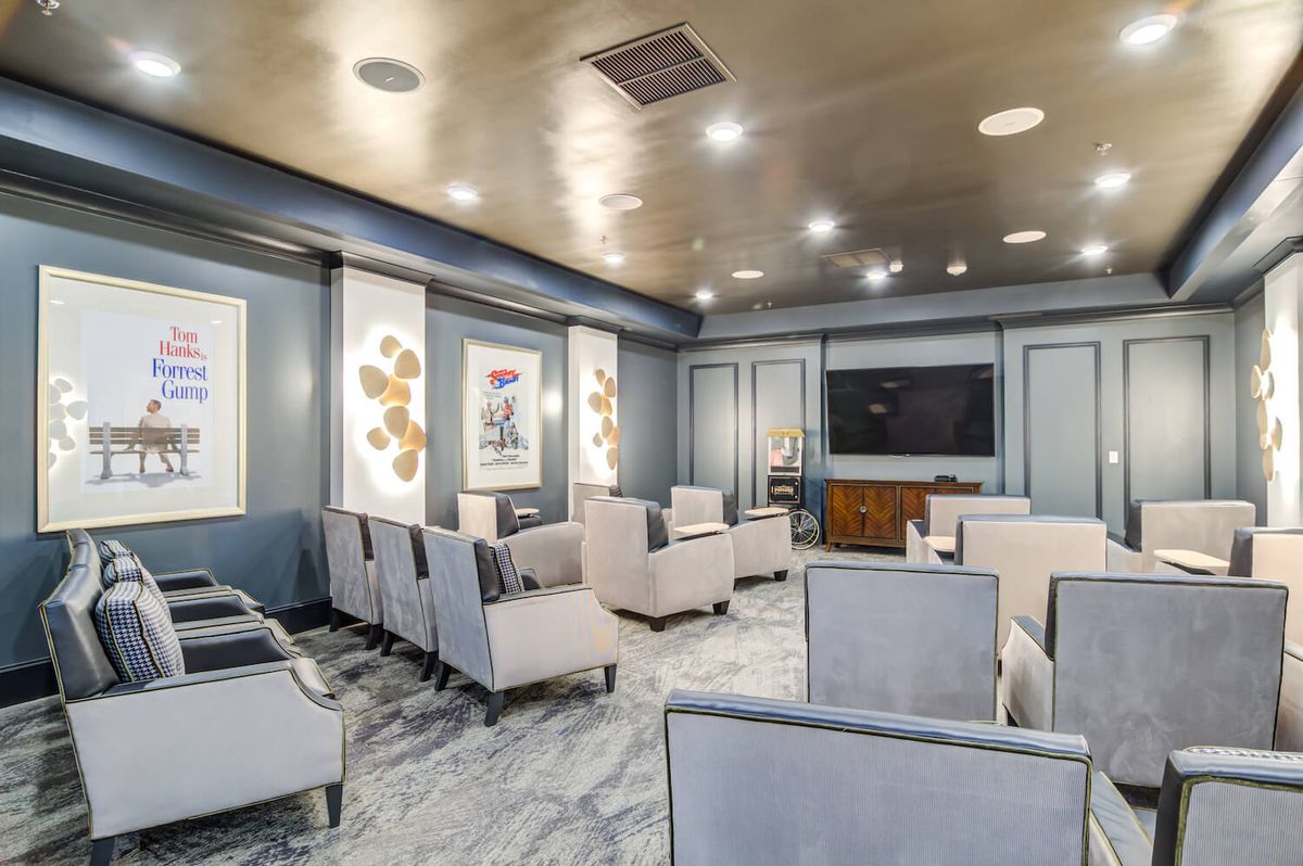 A modern lounge area with comfortable seating, a television, and decorative artwork.