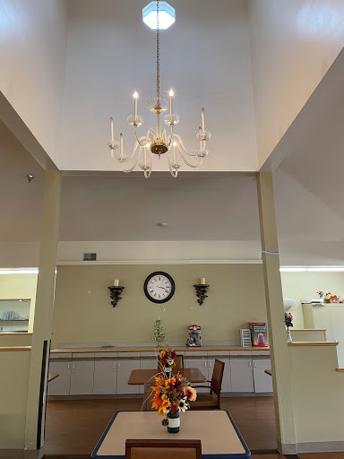 A well-decorated dining area featuring a chandelier, a wall clock, and mirrored walls.