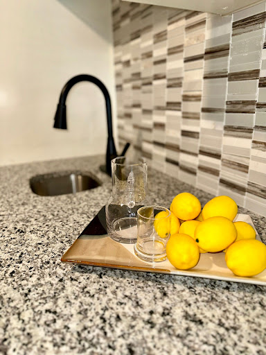 A stylish kitchen setup featuring fresh lemons and elegant glassware on a granite countertop.