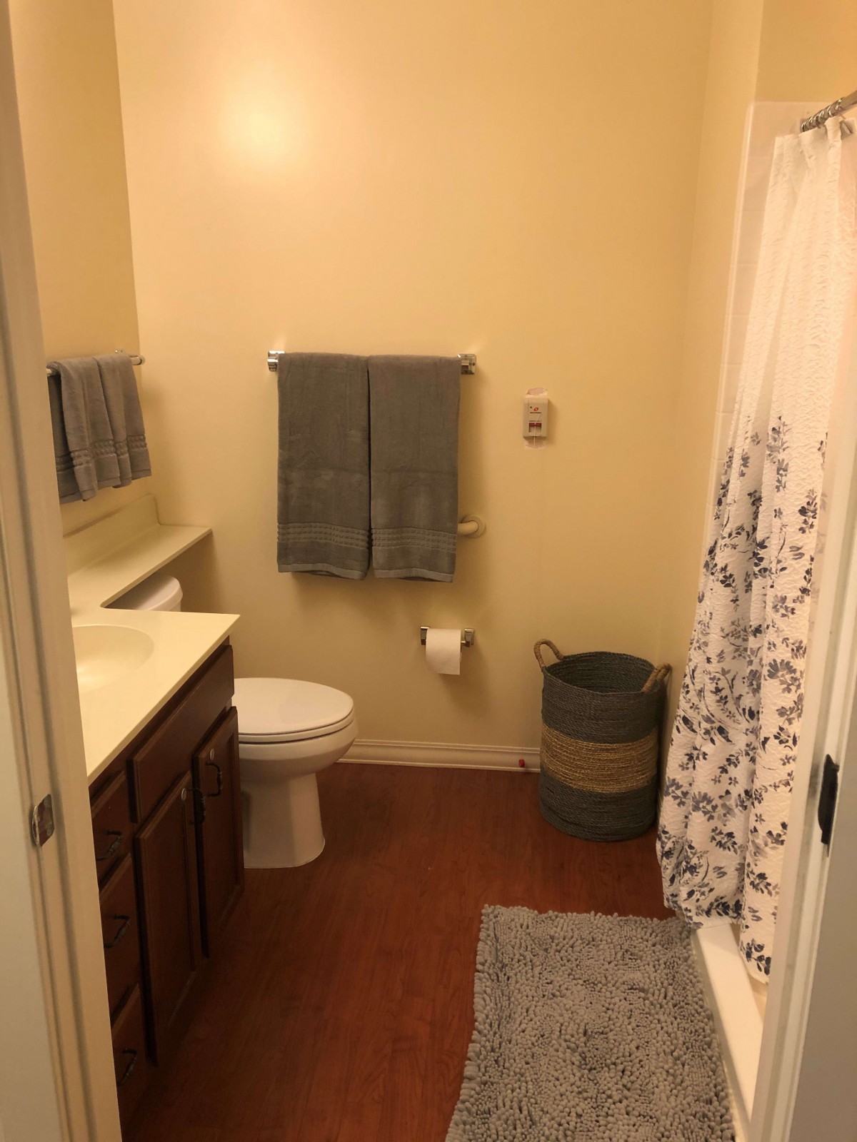 A clean and organized bathroom with towels, a toilet, a sink, and a shower curtain.