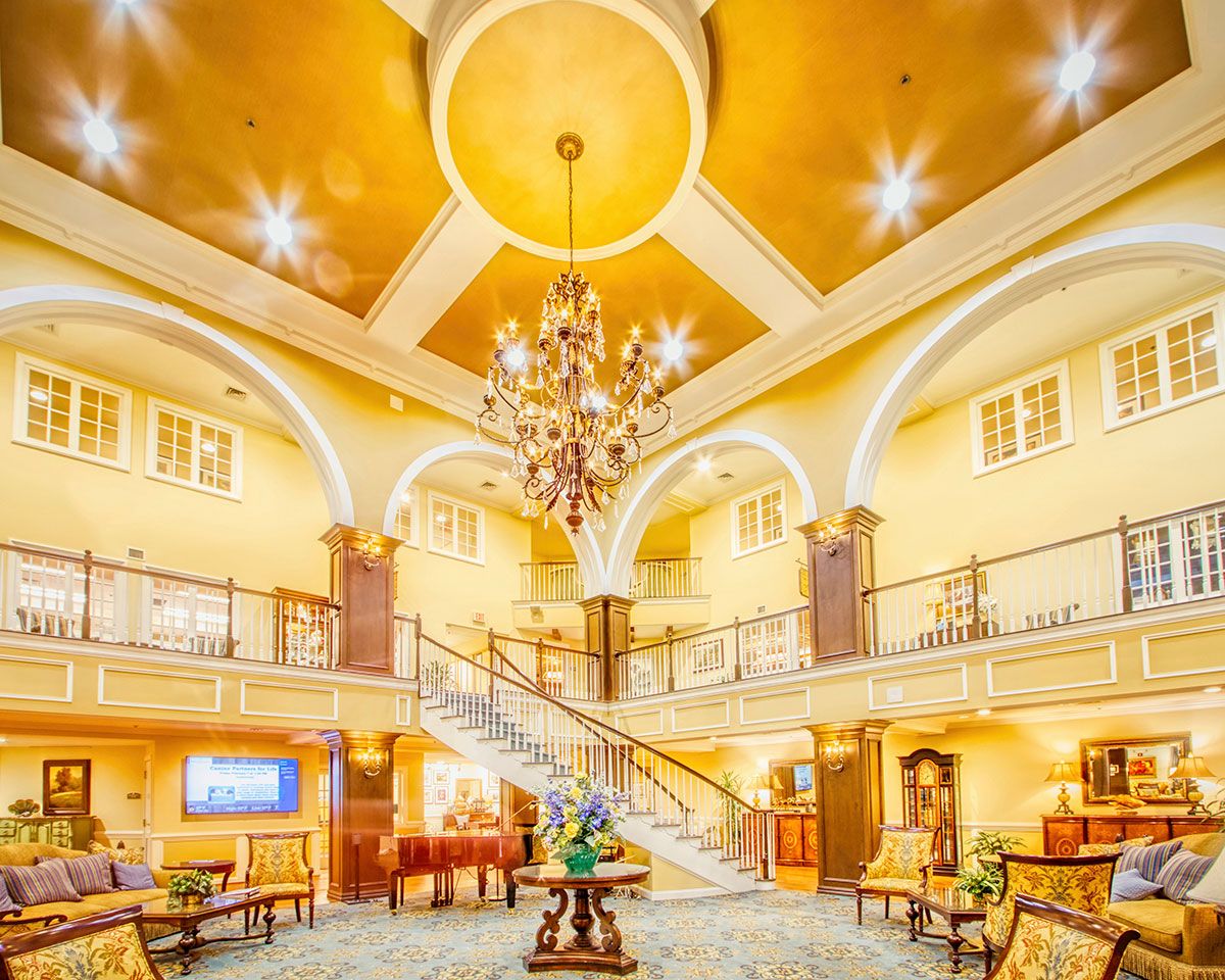 A luxurious hotel lobby featuring a grand staircase and an elegant chandelier.
