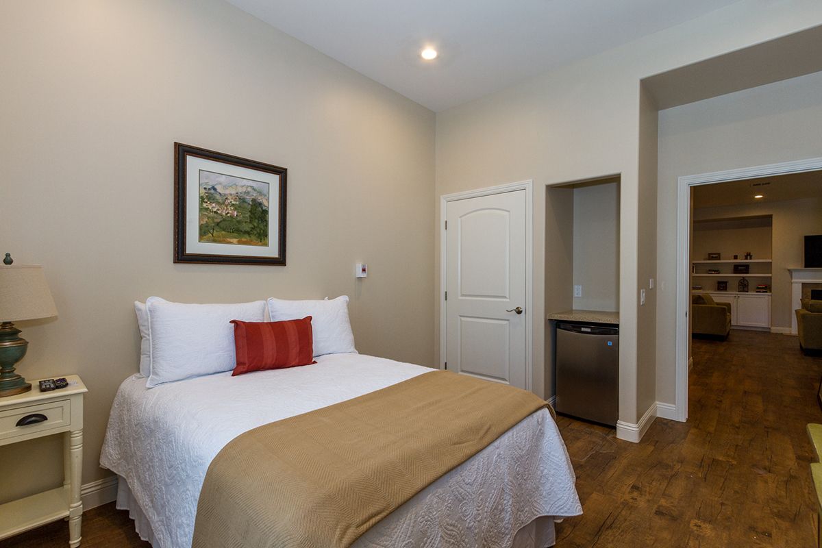 A cozy bedroom with a neatly made bed and wall art.