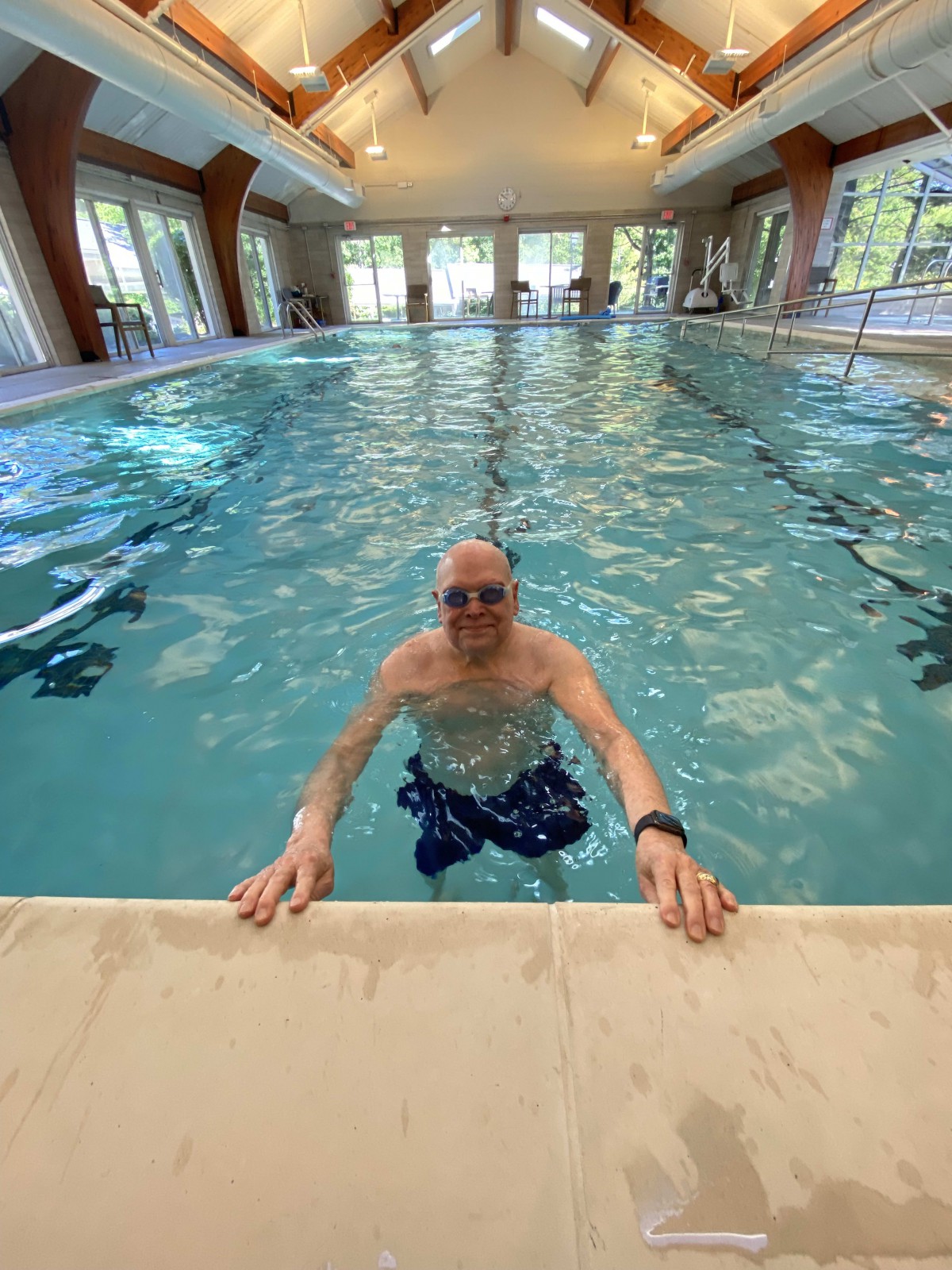 A person enjoying a swim in an indoor swimming pool.