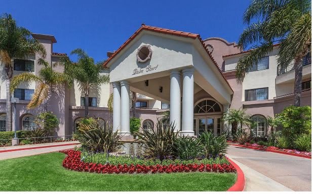 Elegant hotel entrance with landscaped gardens and classic architectural design.