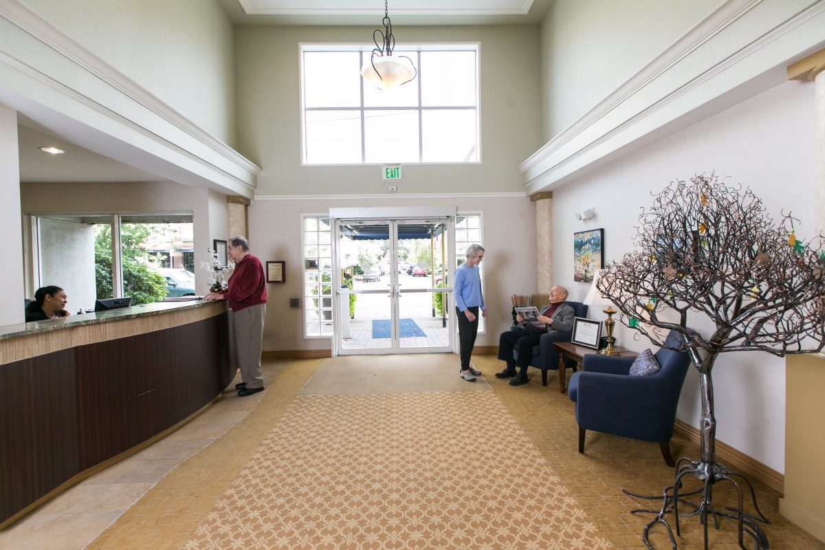 A spacious lobby with people checking in and waiting.