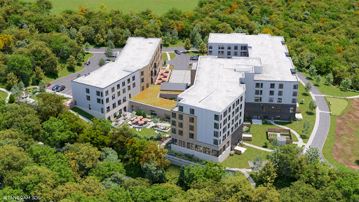 Aerial view of a modern architectural complex surrounded by lush greenery.