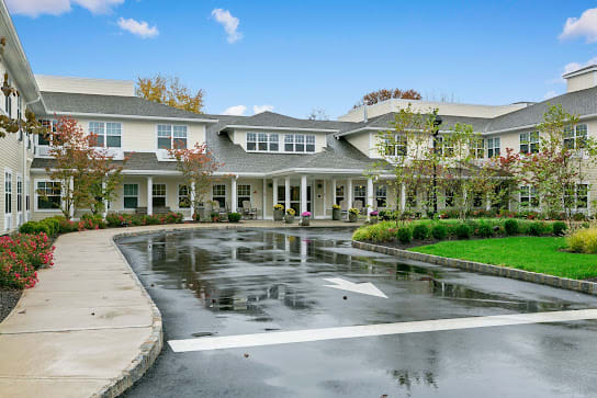 A large residential building with a driveway and landscaped surroundings.